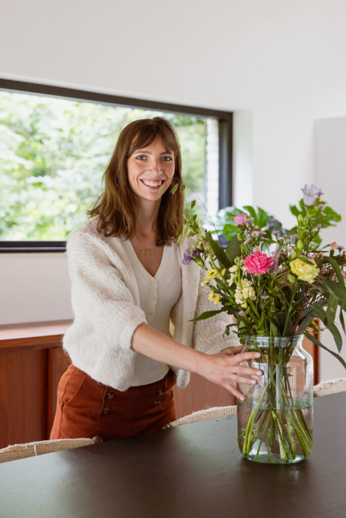 Isabelle van De Woonmakelaar zet bloemen op tafel en maakt van je huis een thuis