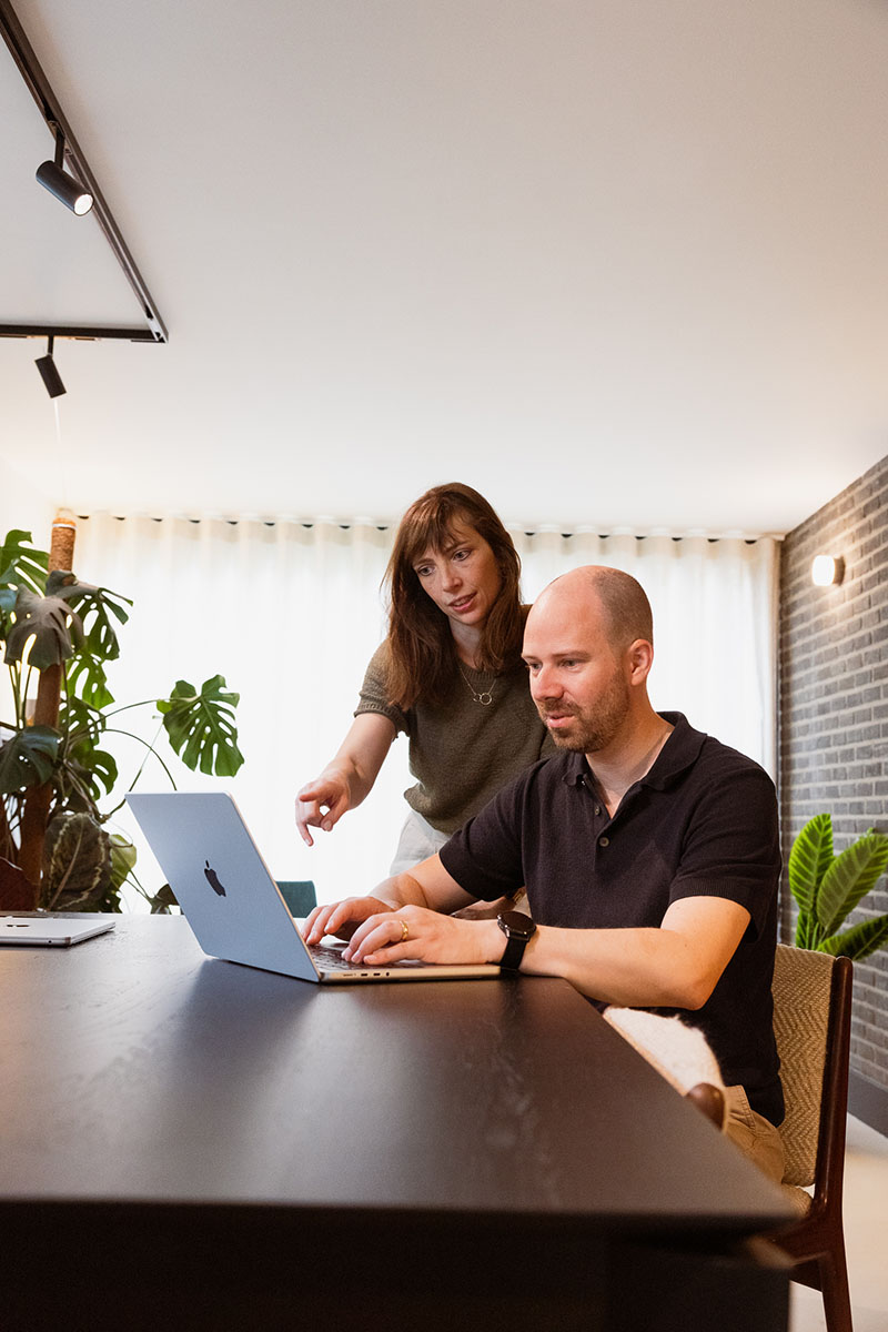 Isabelle en Wouter van De Woonmakelaar bekijken vacatures op een laptop